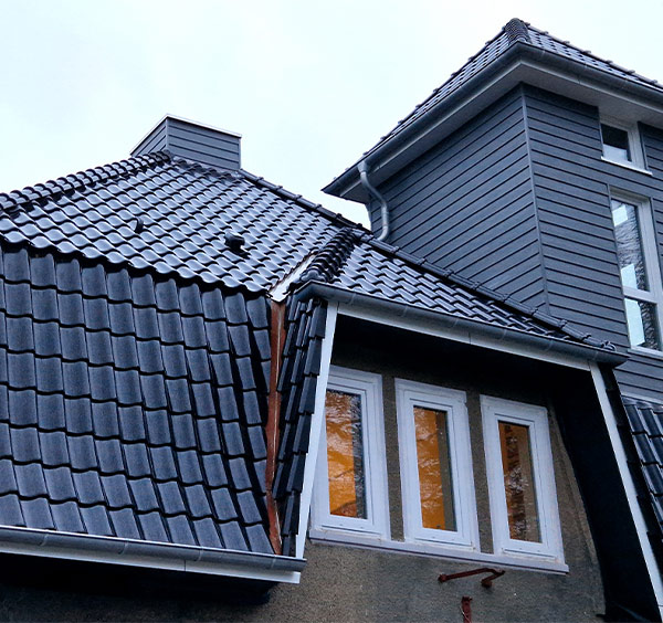 Dachdecker Stockelsdorf - Fertige Dachsanierung in Reinfeld mit anthraziten Dachziegel hochglänzend